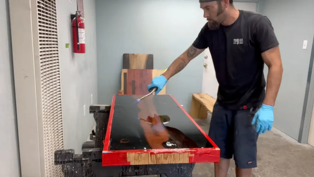 using a flame to eliminate air bubbles after the resin pour