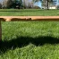 Redwood bench sitting in the grass side angle photo