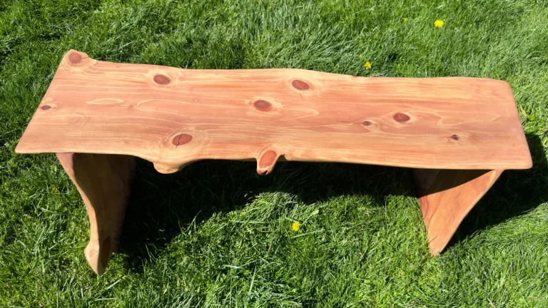 Redwood bench sitting in the grass