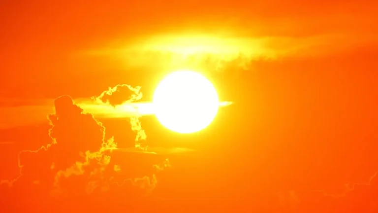 Bright Sun shining in th esky partially covered by clouds